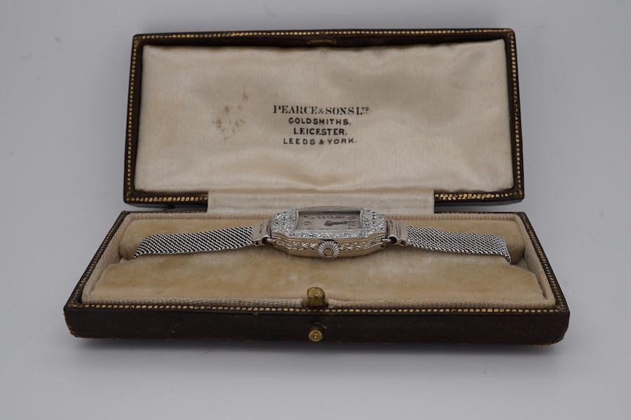 A lady's mid 20th century Swiss white metal(platinum mark) and diamond set cocktail watch with 'tumbling' Arabic numeral dial, on a 9ct white metal mesh link bracelet, case diameter 16mm, overall length 16cm, gross weigh
